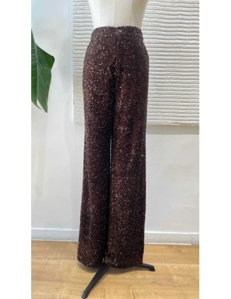 Traje de chaqueta en lentejuelas compuesto por chaqueta entallada y boton metalizado combinado con pantalón palazzo y bolsillos