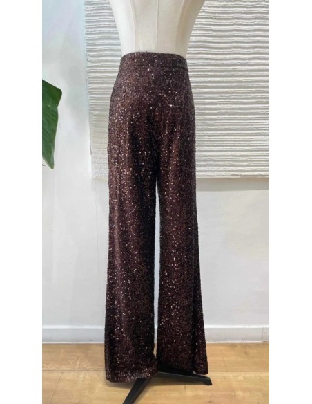 Traje de chaqueta en lentejuelas compuesto por chaqueta entallada y boton metalizado combinado con pantalón palazzo y bolsillos