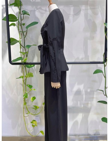 Traje de chaqueta compuesto por chaqueta entallada con lazada combinado con pantalón palazzo. Detalle de pedrería en ambas pieza