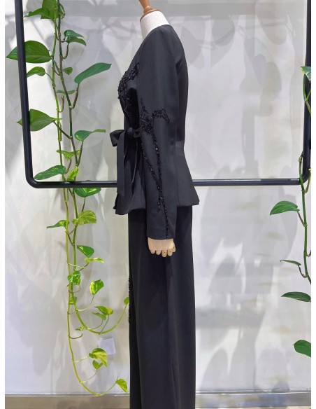 Traje de chaqueta compuesto por chaqueta entallada con lazada combinado con pantalón palazzo. Detalle de pedrería en ambas pieza