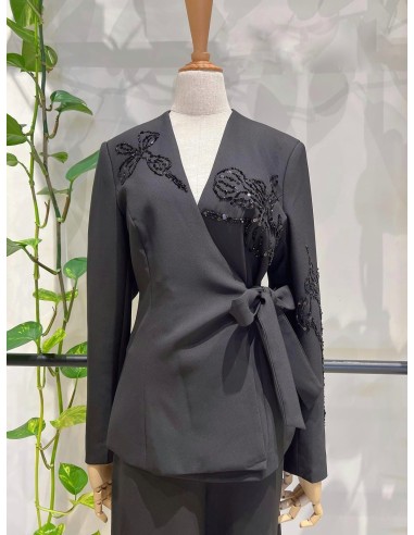 Traje de chaqueta compuesto por chaqueta entallada con lazada combinado con pantalón palazzo. Detalle de pedrería en ambas pieza