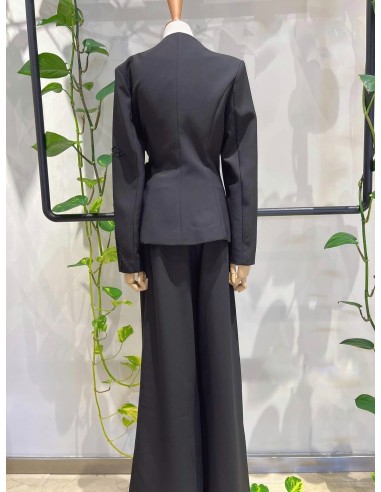 Traje de chaqueta compuesto por chaqueta entallada con lazada combinado con pantalón palazzo. Detalle de pedrería en ambas pieza