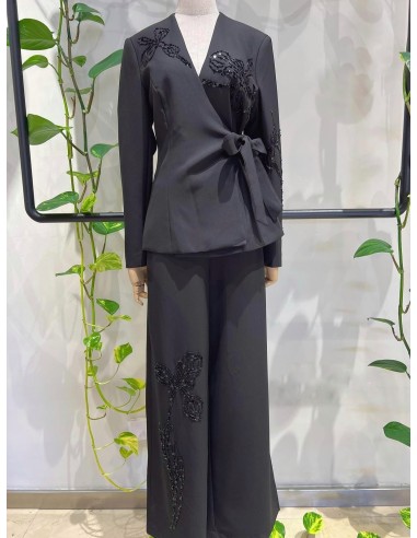 Traje de chaqueta compuesto por chaqueta entallada con lazada combinado con pantalón palazzo. Detalle de pedrería en ambas pieza