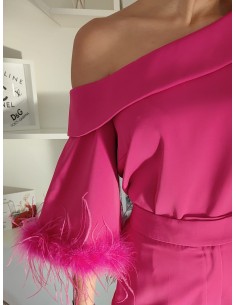 Conjunto de camisa con escote asimétrico y pantalón cropped de trio alto. Detalle de plumas en mangas y bajos de pantalón.