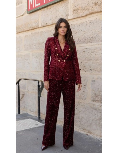 Traje de chaqueta en lentejuelas compuesto por chaqueta entallada y boton metalizado combinado con pantalón palazzo y bolsillos