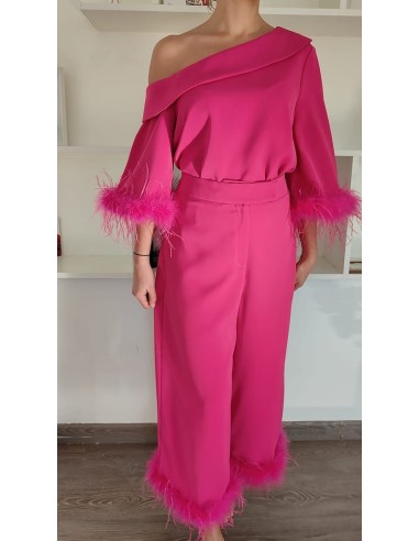 Conjunto de camisa con escote asimétrico y pantalón cropped de trio alto. Detalle de plumas en mangas y bajos de pantalón.