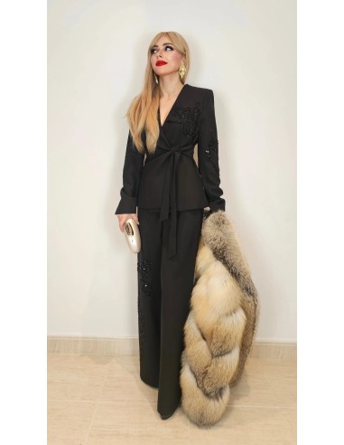 Traje de chaqueta compuesto por chaqueta entallada con lazada combinado con pantalón palazzo. Detalle de pedrería en ambas pieza