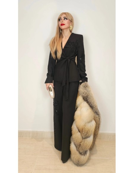 Traje de chaqueta compuesto por chaqueta entallada con lazada combinado con pantalón palazzo. Detalle de pedrería en ambas pieza