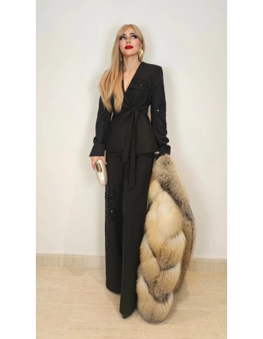Traje de chaqueta compuesto por chaqueta entallada con lazada combinado con pantalón palazzo. Detalle de pedrería en ambas pieza