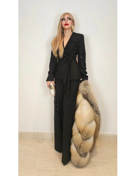 Traje de chaqueta compuesto por chaqueta entallada con lazada combinado con pantalón palazzo. Detalle de pedrería en ambas pieza