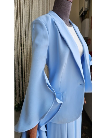 Prepárate para ser el centro de atención con este traje de falda pantalón con pinzas y chaqueta de solapa con detalle de volante