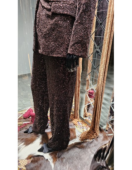 Traje de chaqueta en lentejuelas compuesto por chaqueta entallada y boton metalizado combinado con pantalón palazzo y bolsillos