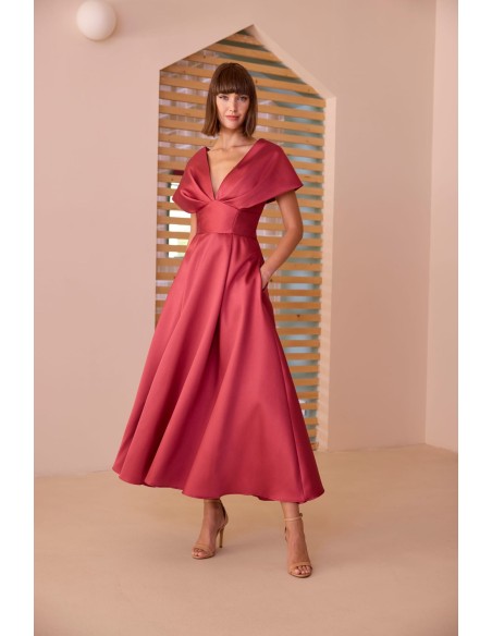 Vestido midi evasé con escote pronunciado. Confeccionado en tejido satinado. Cintura marcada y falda amplia con una elegante caí