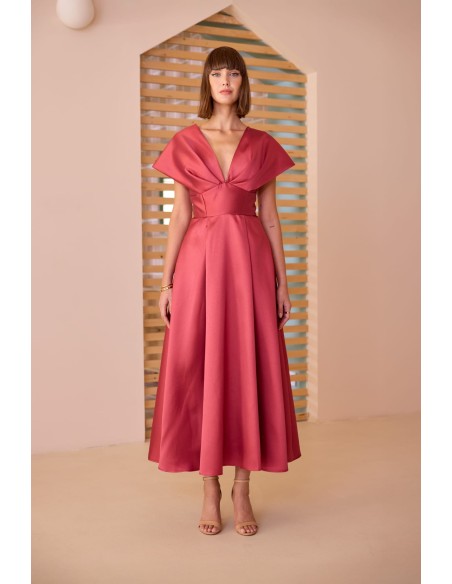 Vestido midi evasé con escote pronunciado. Confeccionado en tejido satinado. Cintura marcada y falda amplia con una elegante caí