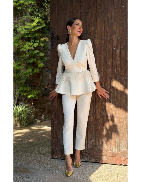 Conjunto de pantalón pitillo estilo sastre y top peplum con manga tres cuartos abullonada y detalle plumas.