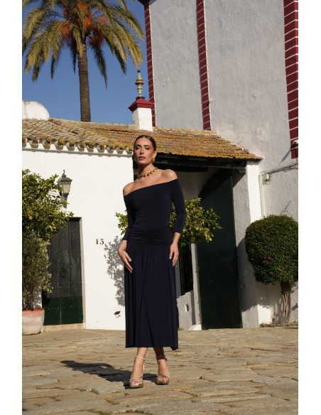 Un vestido midi con escote bardot y mangas tres cuartos. Destaca por su vuelo en el bajo que aporta movimiento y gracia.
