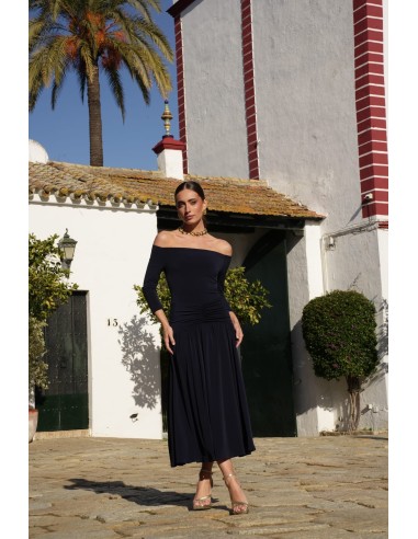 Un vestido midi con escote bardot y mangas tres cuartos. Destaca por su vuelo en el bajo que aporta movimiento y gracia.