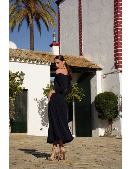 Un vestido midi con escote bardot y mangas tres cuartos. Destaca por su vuelo en el bajo que aporta movimiento y gracia.