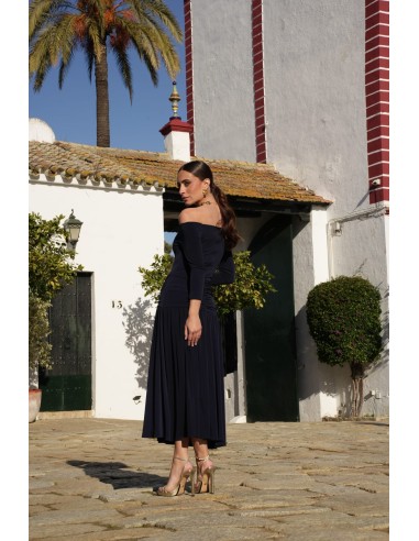 Un vestido midi con escote bardot y mangas tres cuartos. Destaca por su vuelo en el bajo que aporta movimiento y gracia.