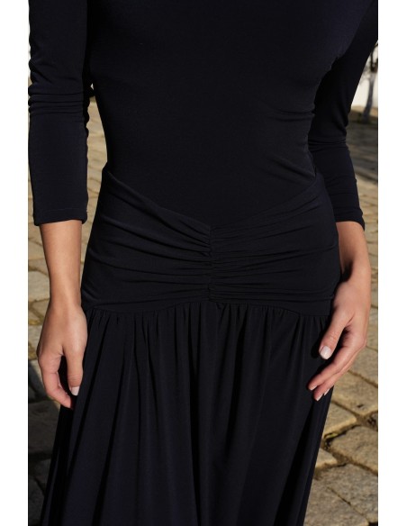 Un vestido midi con escote bardot y mangas tres cuartos. Destaca por su vuelo en el bajo que aporta movimiento y gracia.