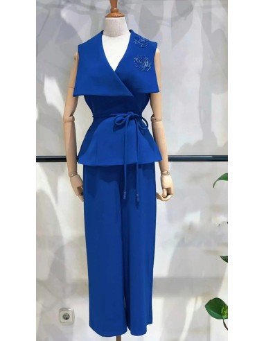 Conjunto de dos piezas compuesto por top maxi solapa con detalle flor en pedrería y pantalón cropped.