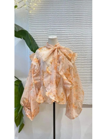 Camisa oversize con estampado floral y detalle de volantes y lazada en el cuello.