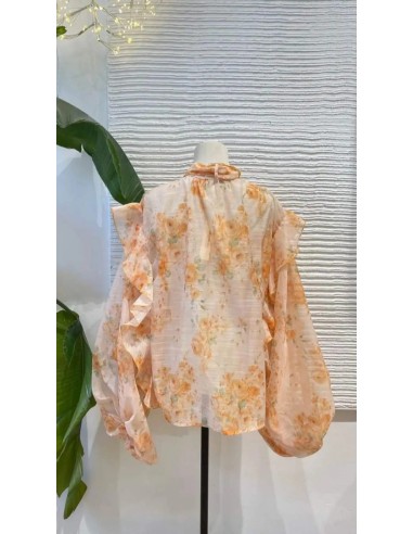 Camisa oversize con estampado floral y detalle de volantes y lazada en el cuello.