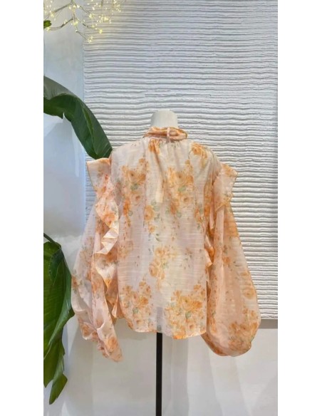 Camisa oversize con estampado floral y detalle de volantes y lazada en el cuello.