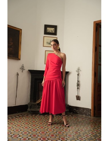 Vestido asimétrico de una sola manga con hombro pronunciado. Con Abertura lateral y falda con vuelo terminada con un gran volant