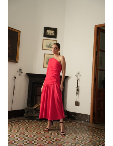 Vestido asimétrico de una sola manga con hombro pronunciado. Con Abertura lateral y falda con vuelo terminada con un gran volant