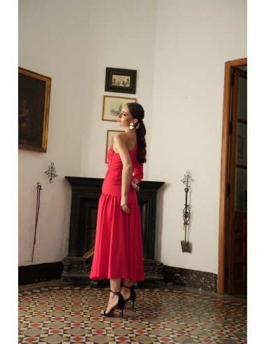 Vestido asimétrico de una sola manga con hombro pronunciado. Con Abertura lateral y falda con vuelo terminada con un gran volant