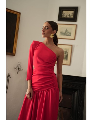 Vestido asimétrico de una sola manga con hombro pronunciado. Con Abertura lateral y falda con vuelo terminada con un gran volant