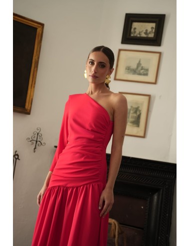 Vestido asimétrico de una sola manga con hombro pronunciado. Con Abertura lateral y falda con vuelo terminada con un gran volant