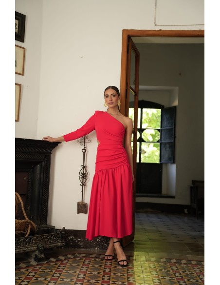 Vestido asimétrico de una sola manga con hombro pronunciado. Con Abertura lateral y falda con vuelo terminada con un gran volant