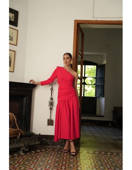 Vestido asimétrico de una sola manga con hombro pronunciado. Con Abertura lateral y falda con vuelo terminada con un gran volant