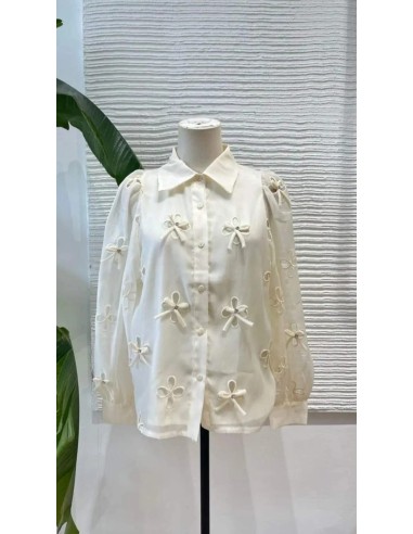 Camisa cuello camisero de lazos y pedrería con tejido fluido de manga larga. Cierre mediante botones delanteros.