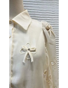 Camisa cuello camisero de lazos y pedrería con tejido fluido de manga larga. Cierre mediante botones delanteros.