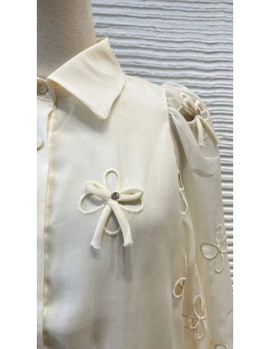 Camisa cuello camisero de lazos y pedrería con tejido fluido de manga larga. Cierre mediante botones delanteros.