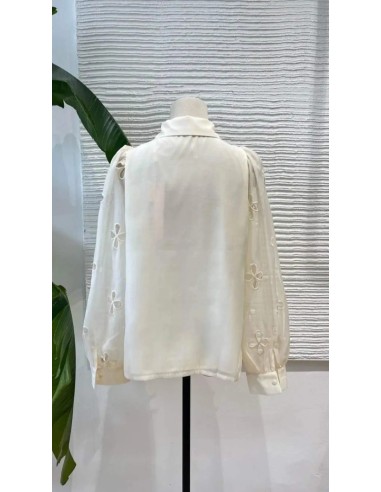 Camisa cuello camisero de lazos y pedrería con tejido fluido de manga larga. Cierre mediante botones delanteros.