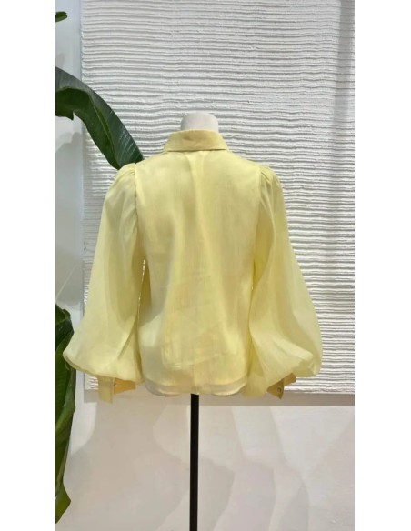 Camisa en gasa con botones y cuello camisero de manga larga abullonada. Forro interior.