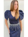 Top ajustado con cuello pico y mangas capa. Cierre mediante cremallera invisible trasera.