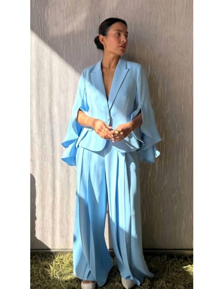 Prepárate para ser el centro de atención con este traje de falda pantalón con pinzas y chaqueta de solapa con detalle de volante