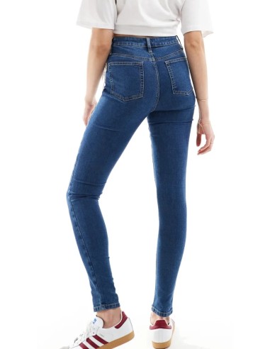 Jeans skinny fit de tiro alto con diseño de cinco bolsillos, cintura con trabillas, y cierre de botón y cremallera.