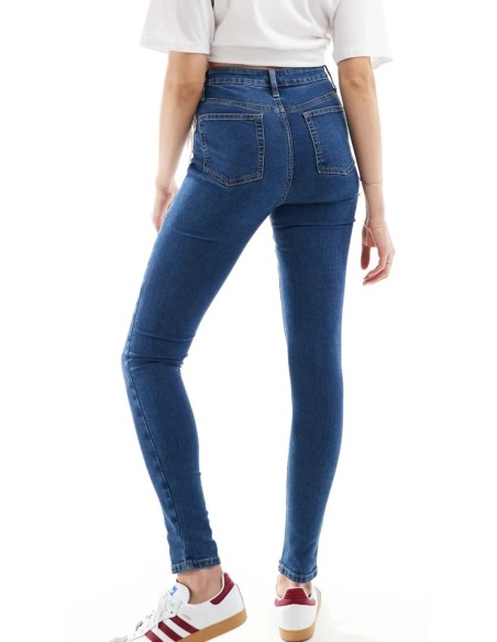 Jeans skinny fit de tiro alto con diseño de cinco bolsillos, cintura con trabillas, y cierre de botón y cremallera.