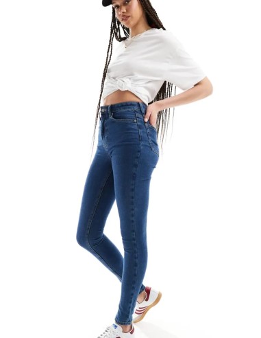 Jeans skinny fit de tiro alto con diseño de cinco bolsillos, cintura con trabillas, y cierre de botón y cremallera.