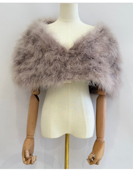 Capa de plumas con cierre frontal mediante broche interior.