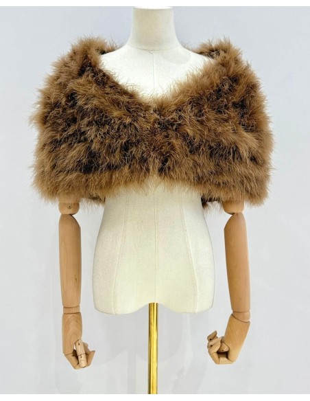 Capa de plumas con cierre frontal mediante broche interior.