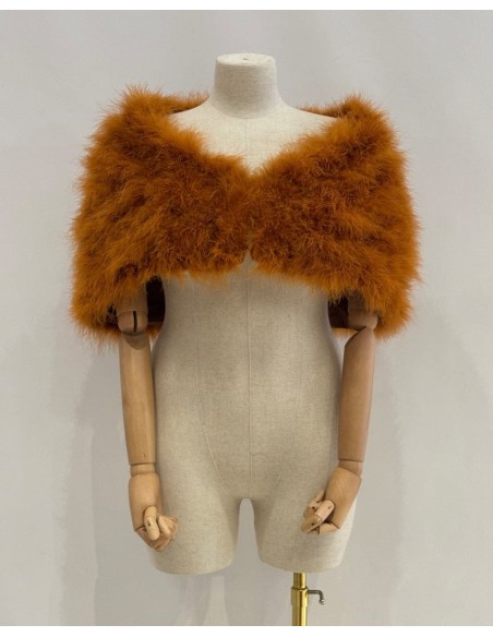 Capa de plumas con cierre frontal mediante broche interior.