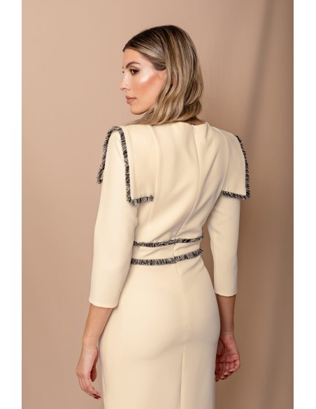 Vestido midi ajustado con pasamanería en hombros y cintura. Forro interior. Cierre mediante cremallera trasera.