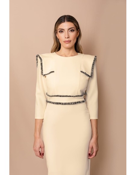 Vestido midi ajustado con pasamanería en hombros y cintura. Forro interior. Cierre mediante cremallera trasera.